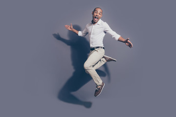 Wall Mural - Full length side profile body size photo amazing dark skin he him his macho jumping high great mood childish playful crazy fooling around wear white shirt pastel pants isolated grey background
