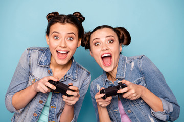 Canvas Print - Close up photo of cute funky hipsters having free time game contest battle speed race using apps playstation gamepad sitting indoors dressed in denim outfit on blue background