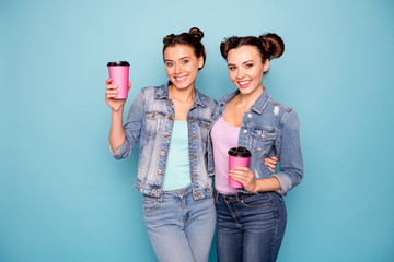 Canvas Print - Portrait of cute charming millennial ladies isolated having refreshments take away go vacation in cafe dressed in denim clothing on azure background 