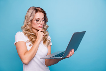 Wall Mural - Portrait of her she nice-looking attractive focused concentrated minded wavy-haired lady in casual white t-shirt holding in hand laptop watching video isolated on blue pastel background