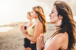 © simona - Goup of young women beautiful healthy friends in yoga meditation outdoor at the beach for wellness active lifestyle concept - sport and people