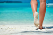 Leinwandbild Motiv Woman walking on tropical white sand beach