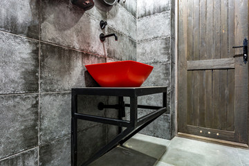 Sticker - Red washbasin with faucet in expensive loft bathroom in elite sport bar on black brick wall background