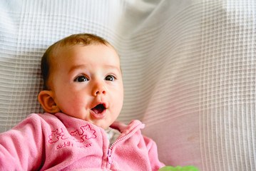 Wall Mural - Pretty and adorable 6 month old baby girl smiling while playing with her mother.