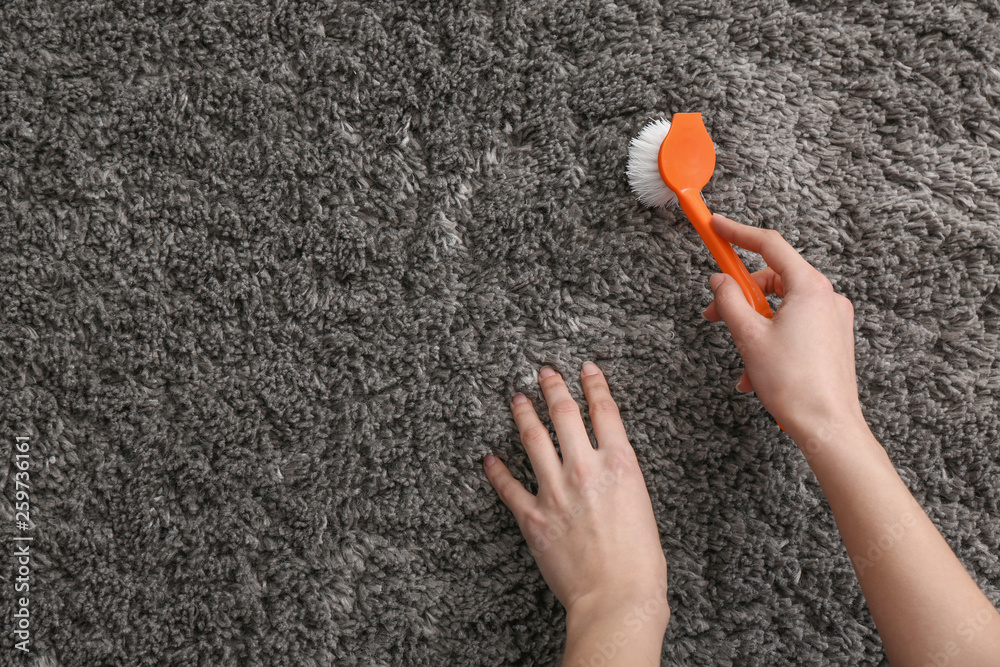 Woman cleaning carpet at home