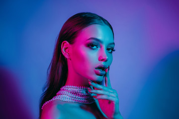high fashion model in colorful bright neon lights posing at studio. portrait of beautiful girl with 
