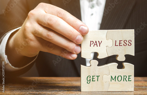Fotografía Businessman collects wooden puzzles with words Pay less get more