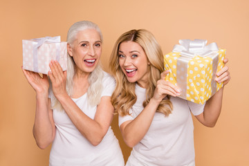 Poster - Portrait of nice-looking winsome lovely attractive charming cute dreamy cheerful cheery positive ladies holding in hands boxes celebrate rejoice isolated over beige pastel background