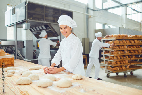Fotografía A woman baker smileswith colleagues at a bakery.
