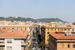 street view of Rome from the top of a building, a road with cars, red tiled roofs
