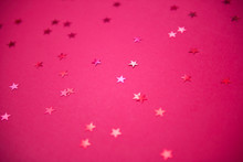 Red Sparkling Sequins Stars On Red Background. Top View, Flat Lay. Copyspace For Text. Bright And Festive Holiday Background.