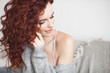 © olenachukhil - Very attractive young woman indoors. Portrait of curly haired female. Redhaired beautiful woman at home.