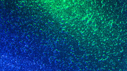 Wall Mural - Blue illuminated liquid with impressive quantity of sparkling air bubbles.