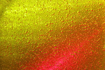 Wall Mural - Golden and red illuminated liquid with shimmering air bubbles.