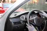 Fototapeta  - Dłonie kierowcy w rękawiczkach na kierownicy samochodu osobowego.