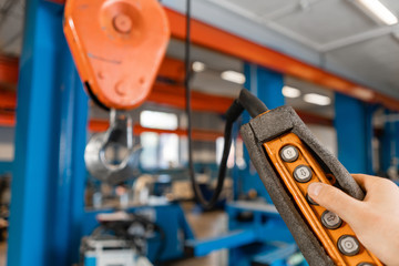 remote control of the crane on production. Workers working with a crane in the warehouse.. the production of ventilation and gutters. Tool and bending equipment for sheet metal.