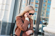 © Galina Zhigalova - Stylish fashionable blonde woman wearing coat and sunglasses speaking on mobile phone at the street