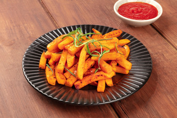 Poster - Sweet potato fries with rosemary and ketchup on a dark rustic wooden background