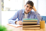teen smiling student on the desk with books