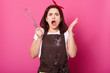© sementsova321 - Energetic emotional female wears dark brown messy apron, white tshirt, accessories, puts her hands up holding whisk. Shocked young lady filled with indignation while practising cooking skills.