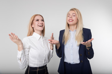 Two beautiful blondes in business suits are happy that the working day is over