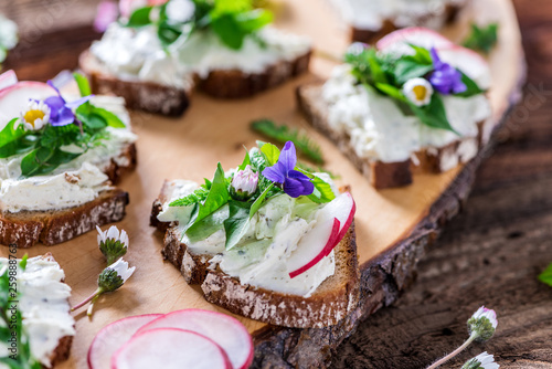 Fotomural Delicious sandwiches with spread of fresh wild meadow herbs, beautifully decorat