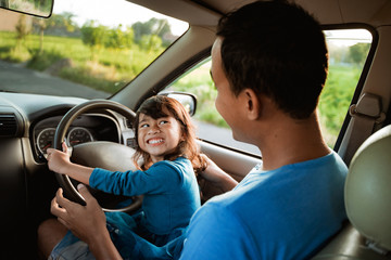 kid playing with steering wheel dad