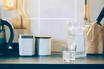 Wall Mural - Glass of pure water on kitchen table.