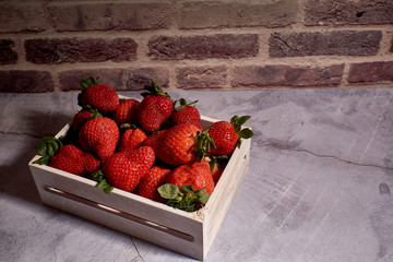 set of tasty red strawberries inside a wooden box