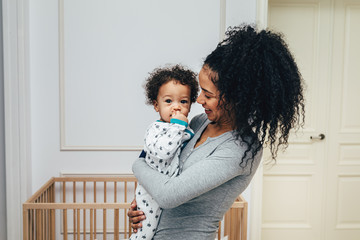 smiling mother holding her child in living room