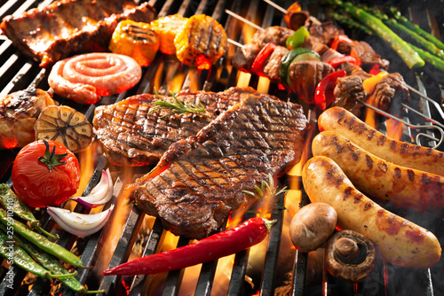 Cuadros en Lienzo Delicious grilled meat with vegetables sizzling over the coals on barbecue