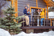 © Grispb - Friends stand on the veranda of a winter cottage. A group of friends rent a cottage at Christmas. Christmas weekend buddies.  Rent a cottage for holidays. Rent a vacation home with friends.