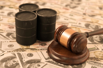 barrels of oil, a judge's hammer, American dollar bills. business, oil industry