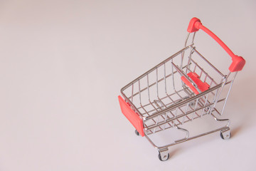 Wall Mural - Red shopping supermarket cart on white background with copy space