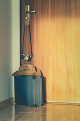 Fototapete - packed suitcase with the camera standing in front of the door, vintage style, the concept of a holiday trip