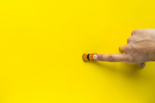 Woman Hand With Little Yellow Toy Car On A Yellow Background. Free Space For Text. Concept