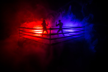 Man and woman boxing on the ring. Sport concept. Artwork decoration with foggy toned dark background.