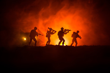 Military soldier silhouette with gun. War Concept. Military silhouettes fighting scene on war fog sky background, World War Soldier Silhouette Below Cloudy Skyline At night.