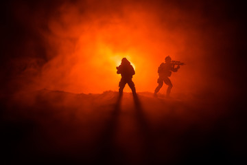 Military soldier silhouette with gun. War Concept. Military silhouettes fighting scene on war fog sky background, World War Soldier Silhouette Below Cloudy Skyline At night.