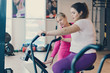 © MZaitsev - Fat female practicing on stationary bike in fitness club