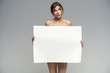 Sexy naked girl with a poster. Clean skin. Hair removed. Isolate. For advertising and presentation.