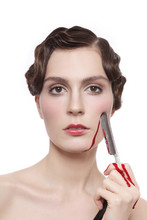 Vintage Style Portrait Of Young Beautiful Woman With Fancy Prom Hairdo And Bloody Blade In Her Hand