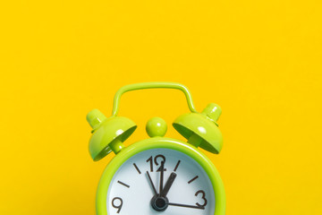 black vintage alarm clock on yellow color background