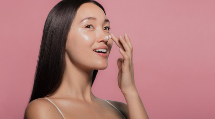 Poster - Youthful female model applying moisturizer