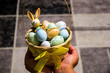 Easter bunny with colorful easter eggs in basket and in hand