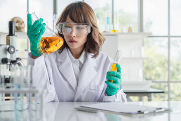 Wall Mural - a young asian woman scientist working in laboratory with test tube microscope and solutions.