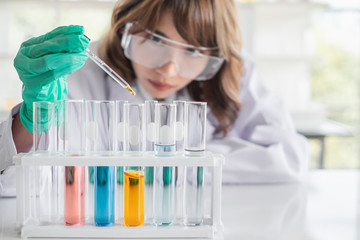 Wall Mural - a young asian woman scientist working in laboratory with test tube microscope and solutions.