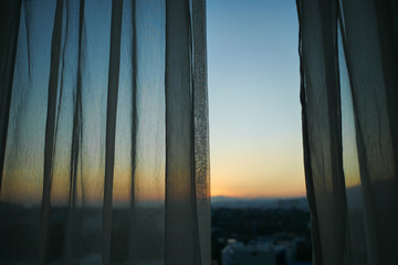 sunlight through white curtain with sunset sky view outside the window