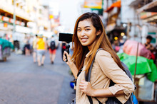 Young Asian Female Tourist Woman Holding A Gimbal With Smartphone And Recording Videos For Blog. Travel Blogger And Vlogger Concept