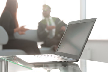 Poster - Focus on laptop on the table. Blurred people on background.